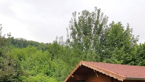 A rustic wooden cabin with a tiled roof, a table with chairs, and a bench. - Ferienwohnung.-monteur/geschäftsleute (Wallerfangen)