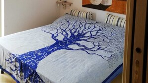 Ein Schlafzimmer mit einem Bett, einem Nachttisch, einer Lampe und zwei Bildern an der Wand.