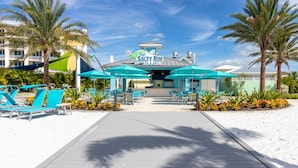 A beachside restaurant with outdoor seating and palm trees.