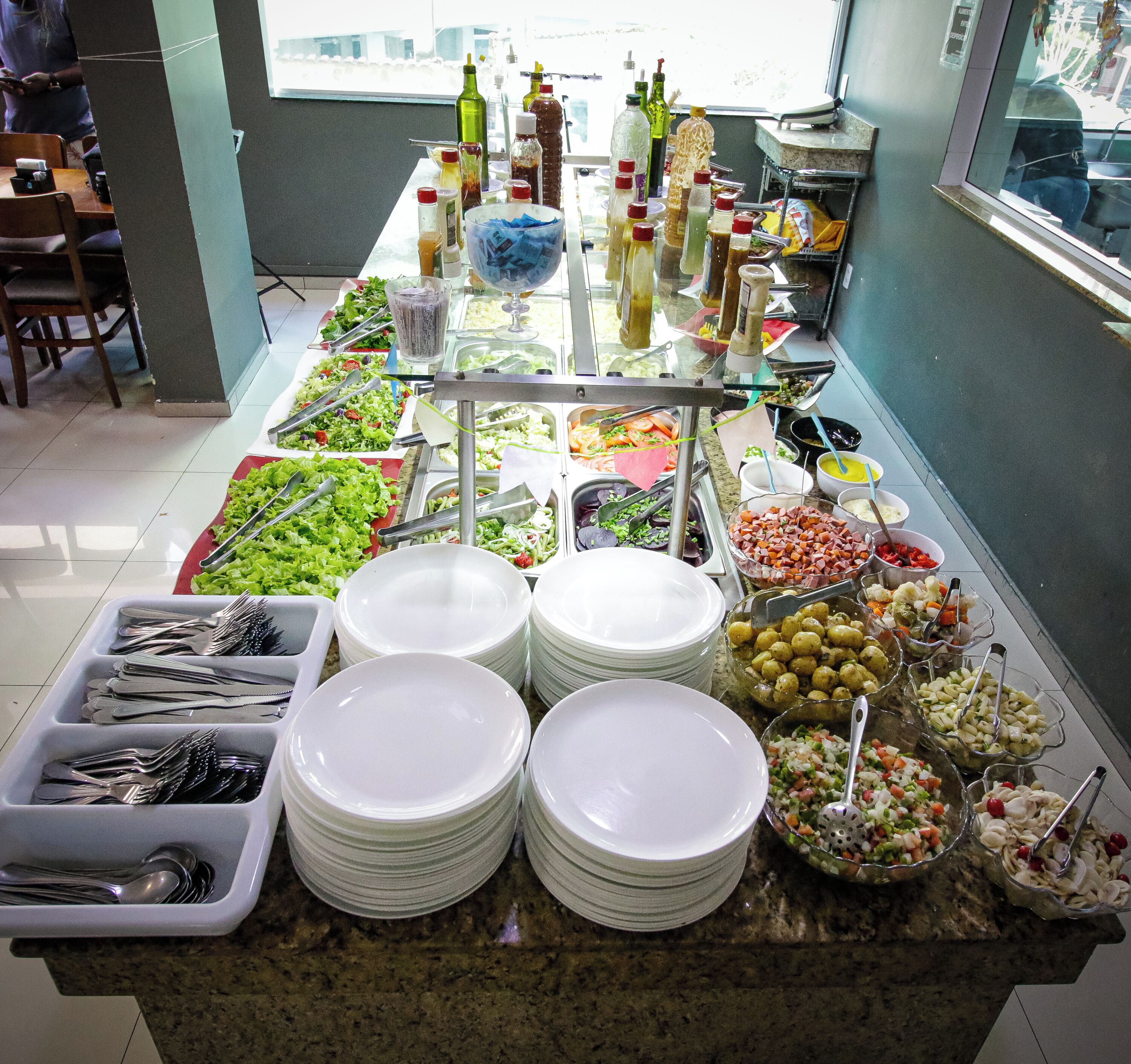 Uma mesa de buffet com diversos alimentos e acompanhamentos.