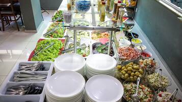 Uma mesa de buffet com diversos alimentos e acompanhamentos.