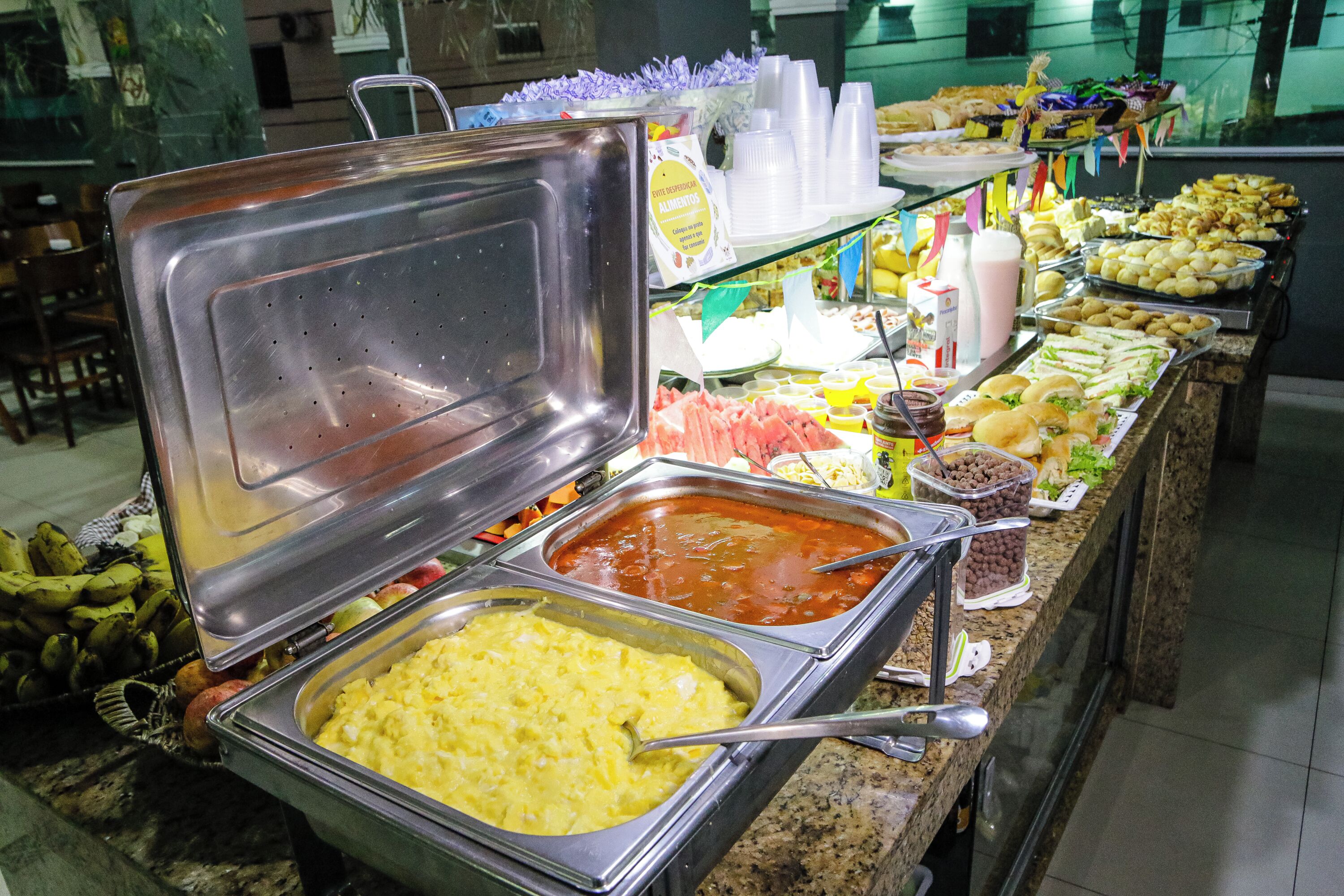 A buffet with various food options including fruits, salads, and beverages.