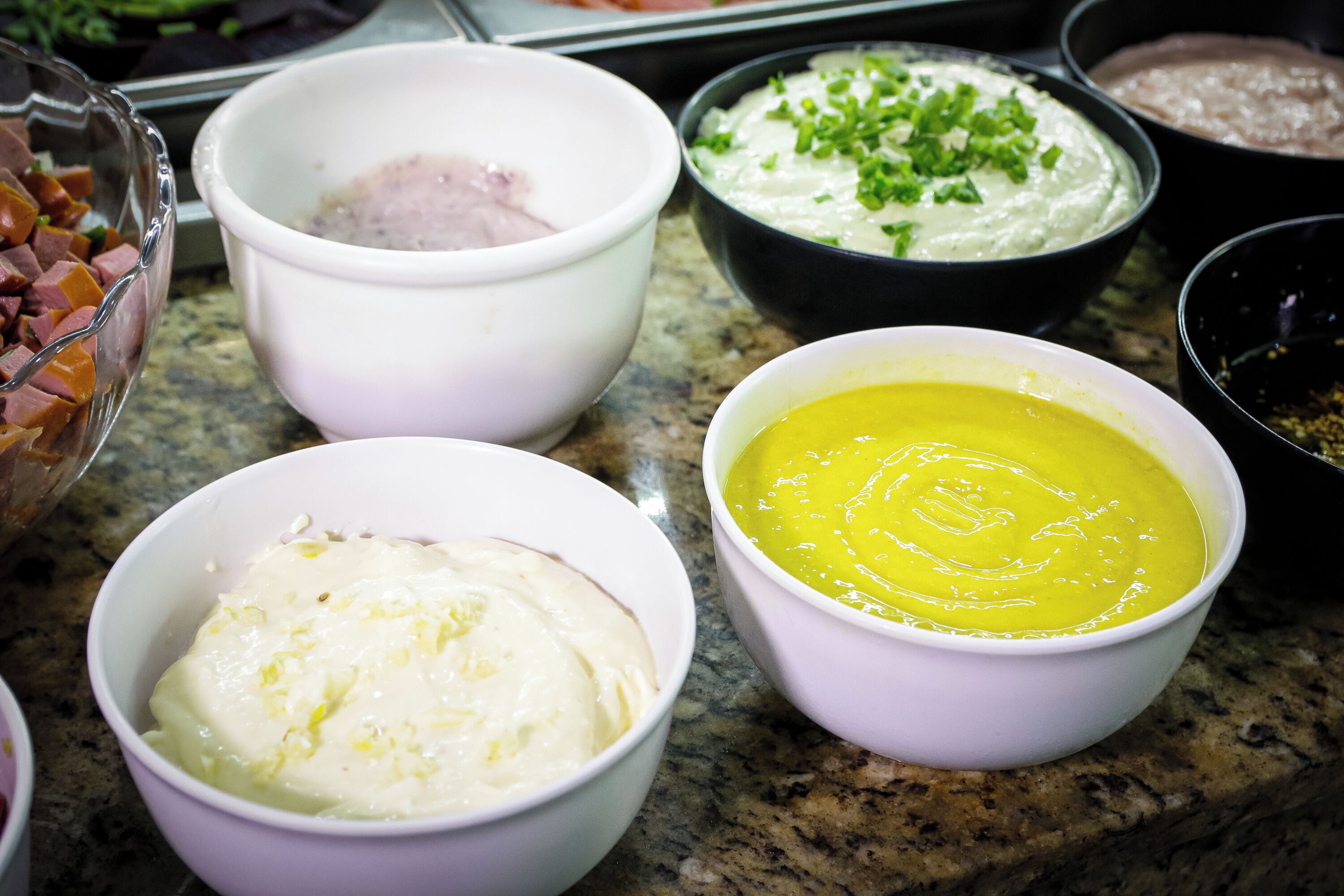 A kitchen counter with various bowls containing different food items.