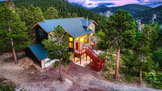 A cabin with a metal roof, a red staircase, and a view of a forested mountain range. - Mountain View Retreat - Epic Views, Pool Table & Garage (Rollinsville)