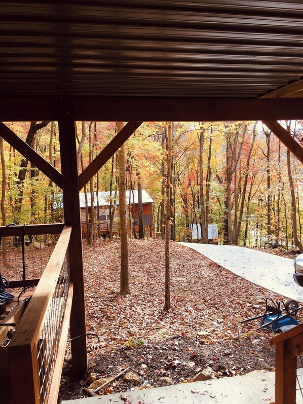 A covered outdoor area with a view of a forested landscape.