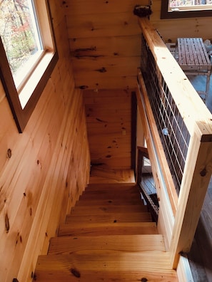 A wooden staircase with a metal railing, leading to a lower level. - Barn Owl Inn Treehouse - Private Hot Tub (Guild)