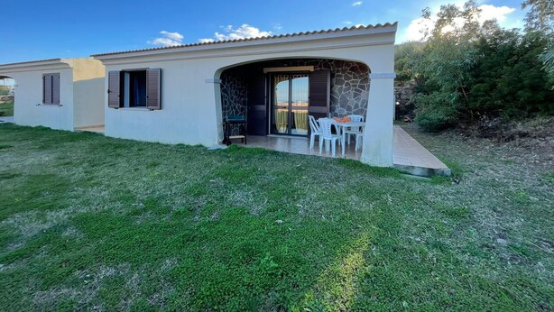 Una casa de un piso con un patio, un muro de piedra y vistas al paisaje.