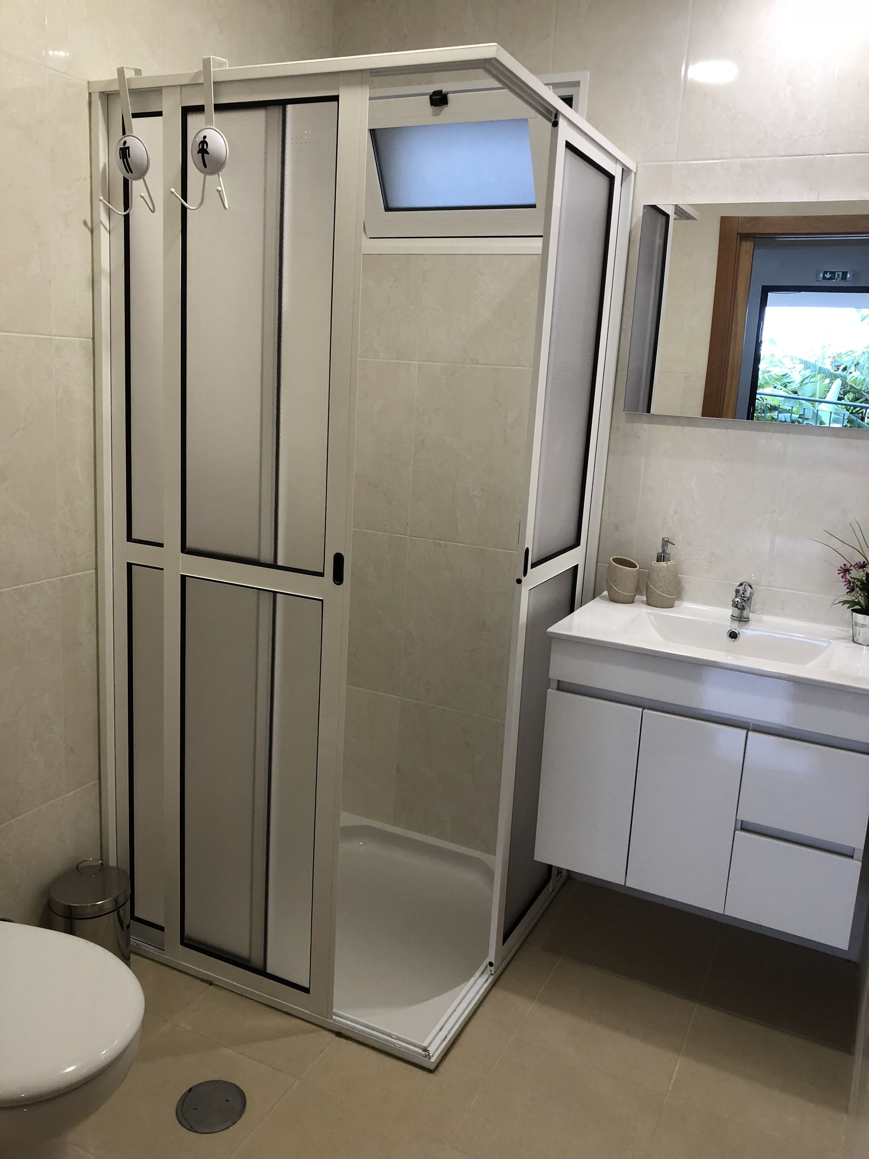 Ein modernes Badezimmer mit barrierefreier Dusche, Toilette und Waschbecken.