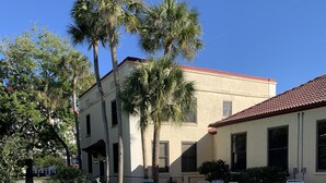 A clear blue pool with a tiled edge, surrounded by lounge chairs and palm trees. - Historic KMI Building - Condo, Park & Street View (Venice)