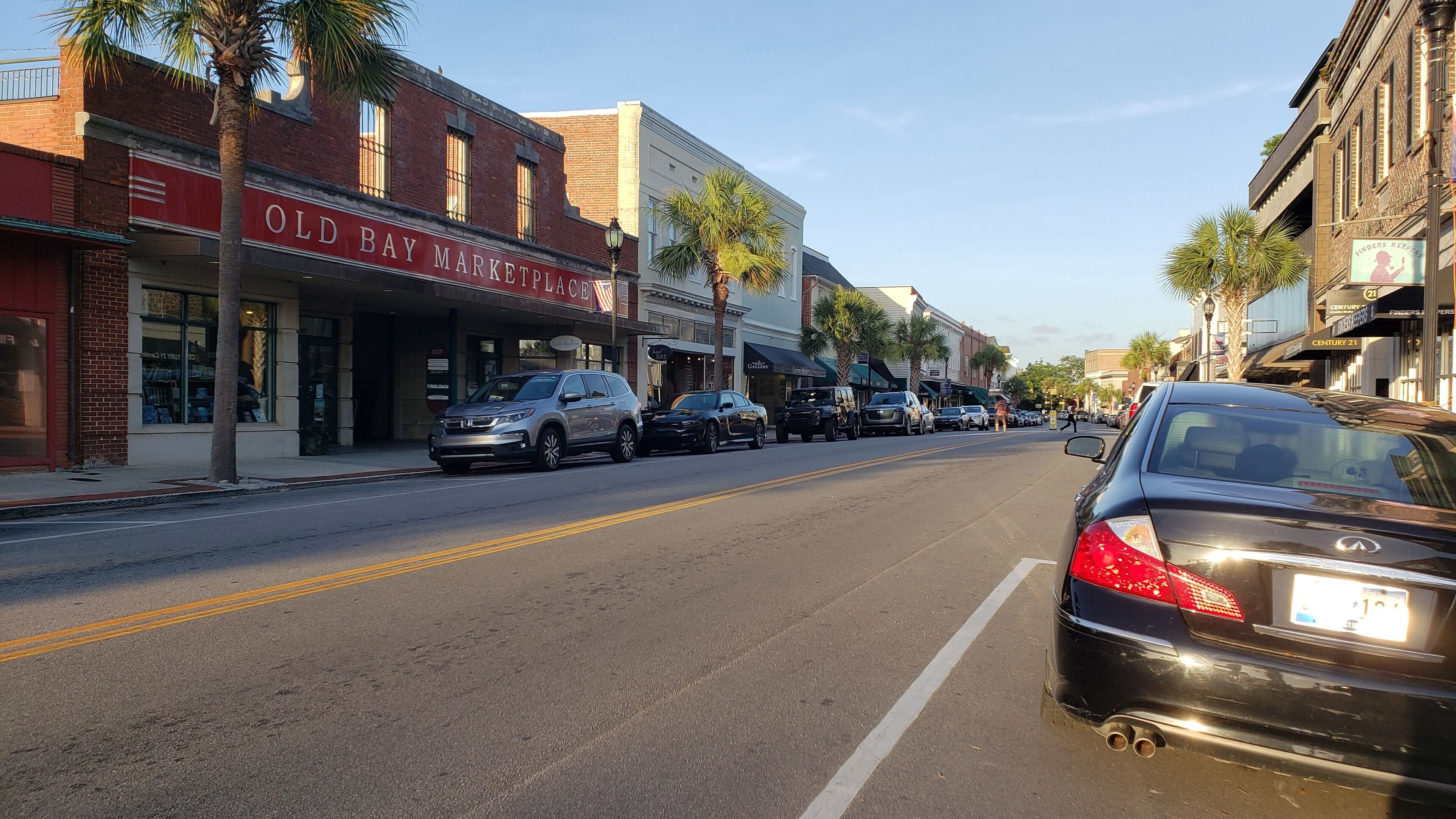 A street lined with shops, including a market and a gallery.