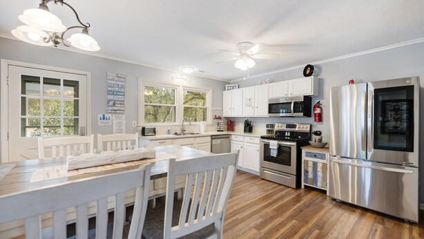 A modern kitchen with white cabinetry, stainless steel appliances, and a wooden floor. - PET FRIENDLY - MINUTES TO PARRIS ISLAND - BEACHES (Beaufort)