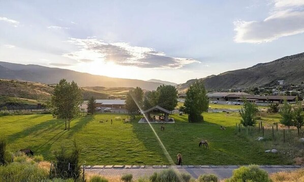 Paisaje rural con un pabellón, campos abiertos y colinas distantes.