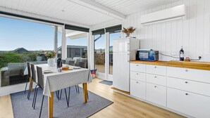 A modern kitchen with a large window, white cabinetry, and a built-in oven.