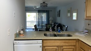 A kitchen with a dishwasher, double sink, and wooden cabinets.