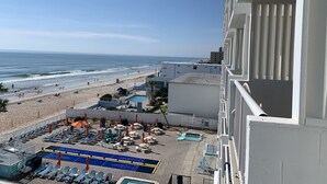 A hotel balcony with a view of the beach and ocean.