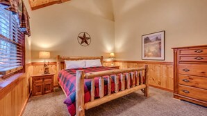 Un dormitorio con una cama de madera, una mesita de noche, un aparador y una ventana con persianas.
