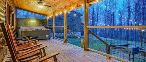 Une terrasse en bois avec des sièges extérieurs et une vue sur les arbres.