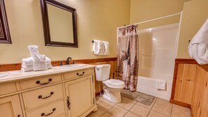 Un baño con tocador, inodoro y zona de ducha.