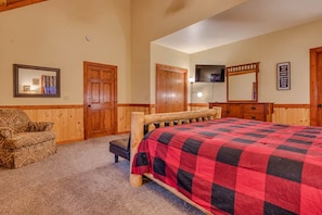 Un dormitorio con cama de madera, una silla, un tocador y un espejo.