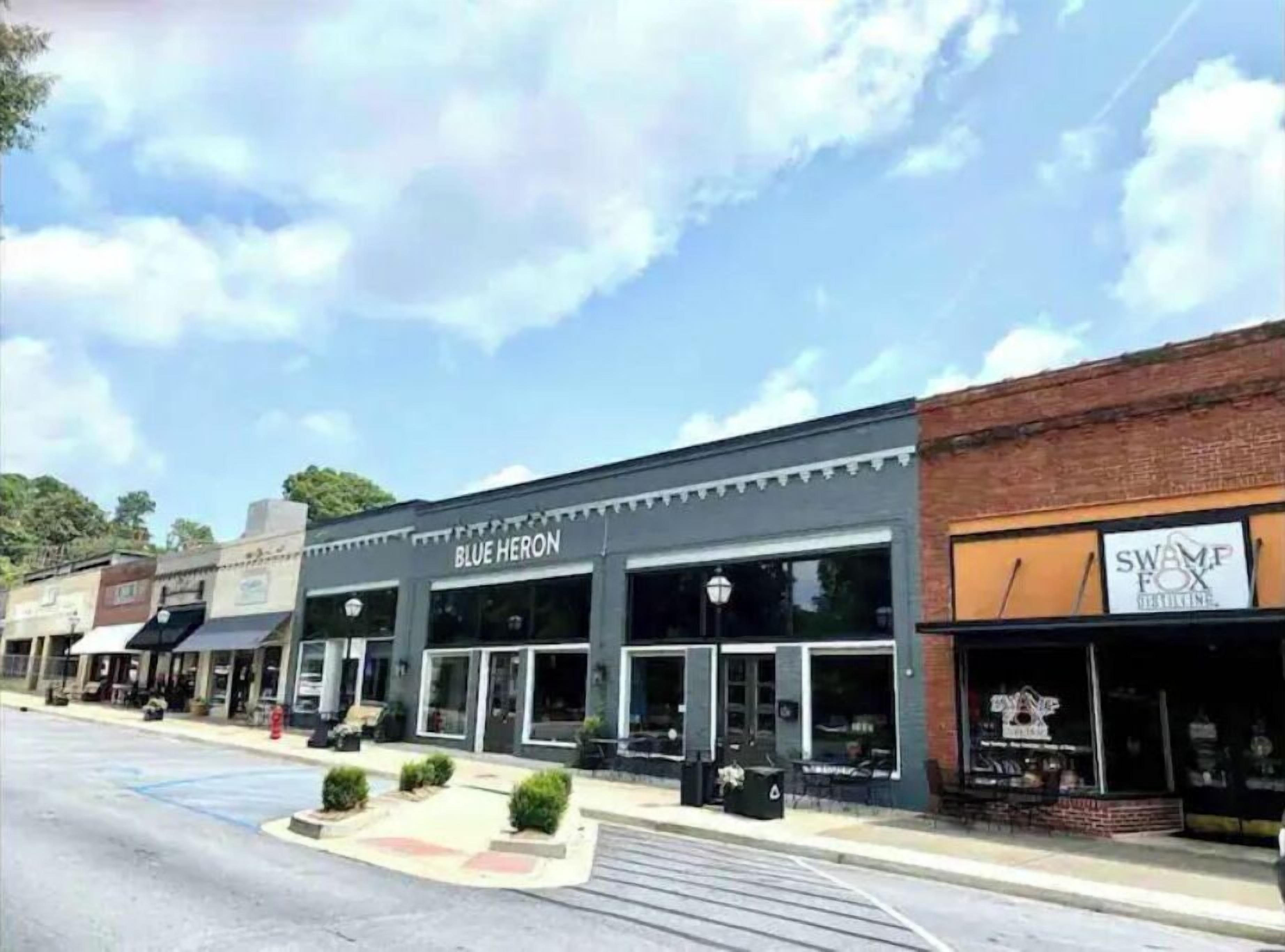 A street view with storefronts including 'Blue Heron' and 'Swamp Fox'.