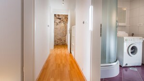 A narrow hallway with wooden flooring leading to a laundry area with a washing machine and a dryer. - Nice home in Col with house a panoramic view (Col)