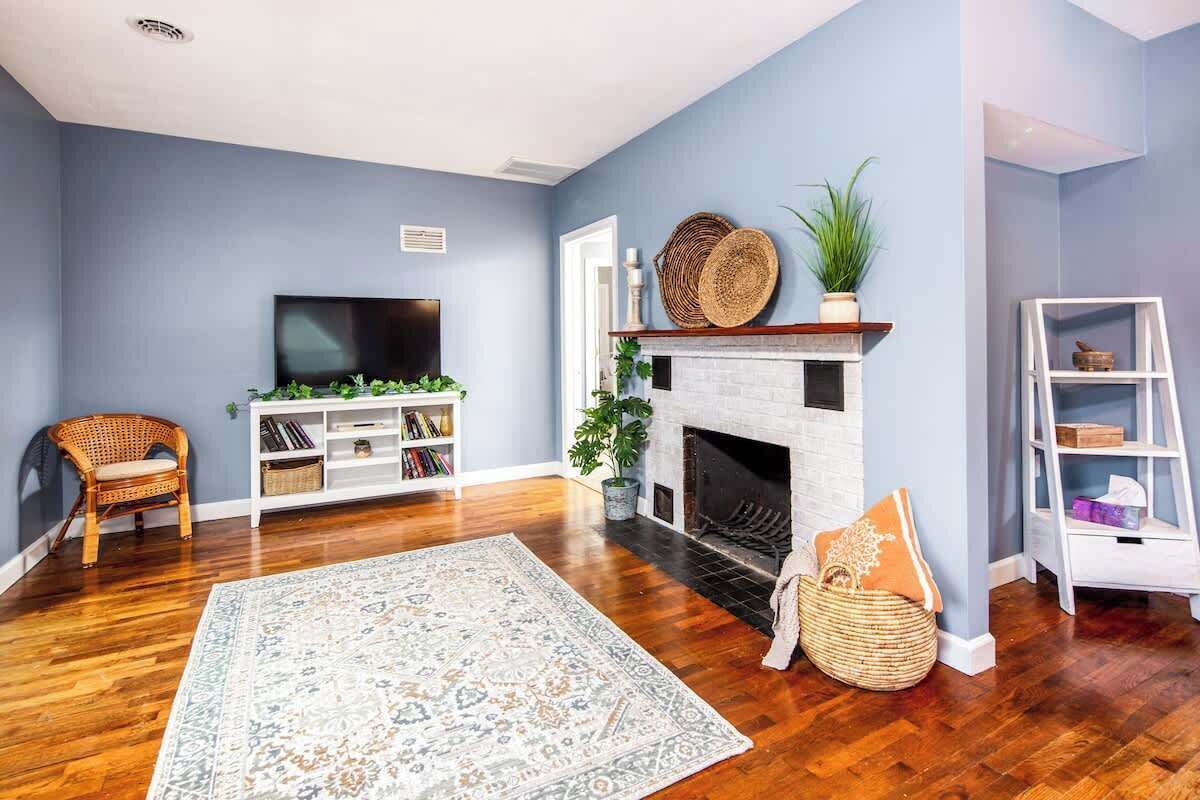 A living room with a fireplace, a television, and a bookshelf.