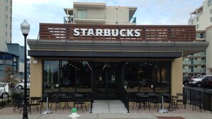 Un Starbucks doté d’une terrasse et d’une borne d’incendie devant l’entrée.