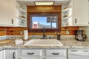 A kitchen with a granite countertop, white cabinets, a window with a view, and a coffee maker. - Clean Secluded Cabin w/ Incredible Mountain Views! (Mexico)