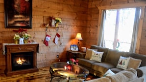 Una sala de estar acogedora con chimenea, un sofá y una mesa de centro.