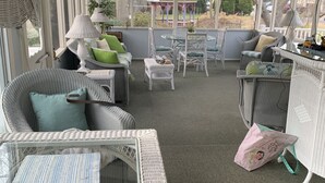 A covered outdoor seating area with wicker furniture, a table, and a TV mounted on the wall. - Lg Victorian, New Resort-likePrivate Pool, Beds for 17, 10min to SH beach (Cape May Court House)