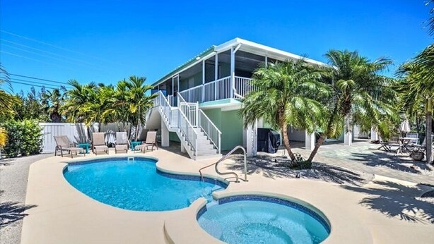 A two-story house with a swimming pool, a covered porch, and palm trees. - 🌴Beach, Pool, Dock,Boating, and Golfing Paradise!!🌴Pets Welcomed! (Marathon)