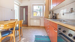 Una cocina compacta con armarios de madera, horno integrado y ventana que proporciona luz natural.