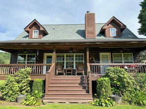 A log cabin with a porch, a chimney, and a set of stairs leading to the entrance. - Riverfront cabin located in the N.E. Georgia Mountains minutes from Lake Chatuge (Hiawassee)