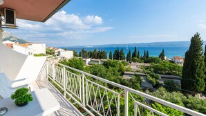 A balcony with a view of the sea, buildings, and greenery. - Gorgeous apartment in Duce with WiFi (Duce)