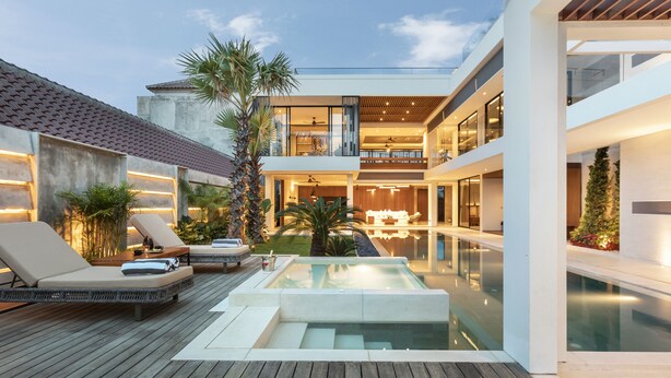 A modern outdoor pool area with lounge chairs, a hot tub, and a wooden deck. - Villa NVL Canggu by Nagisa Bali (Canggu)