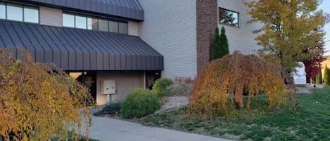 A modern building with a flat roof, a brick chimney, and a paved walkway.