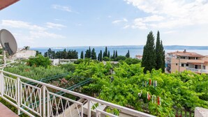 A balcony with a view of a coastal landscape, including trees and buildings. - Stunning apartment in Duce with house sea view (Duce)