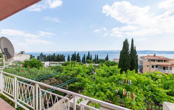 A balcony with a view of a coastal landscape, including trees and buildings. - Stunning apartment in Duce with house sea view (Duce)