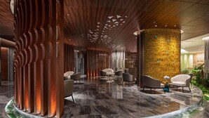 Un vestíbulo moderno con una zona de estar circular, paneles de madera y una pared decorativa con diseños geométricos.