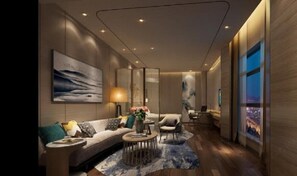 Una sala de estar moderna con un sofá, sillones, una mesa de centro y un amplio ventanal con vistas a la ciudad.