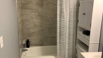 Bathtub, hair dryer, towels, shampoo