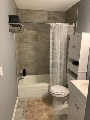 Bañera, secador de pelo, toallas, shampoo