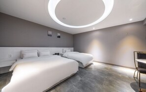 Una habitación de hotel moderna con dos camas, un aplique circular y un diseño minimalista.
