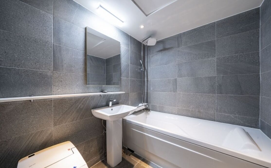 Un bagno moderno con una vasca, un lavandino e uno specchio.