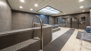 Un baño moderno con una bañera grande, una ducha con mampara de vidrio y un tocador.