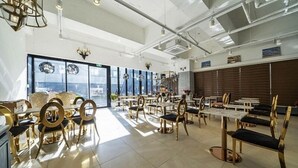 Un restaurante espacioso con techos altos, mobiliario moderno y amplios ventanales con vistas.