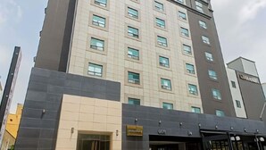 Un hotel moderno con un ingresso ben visibile, diversi piani e una segnaletica che indica i servizi.