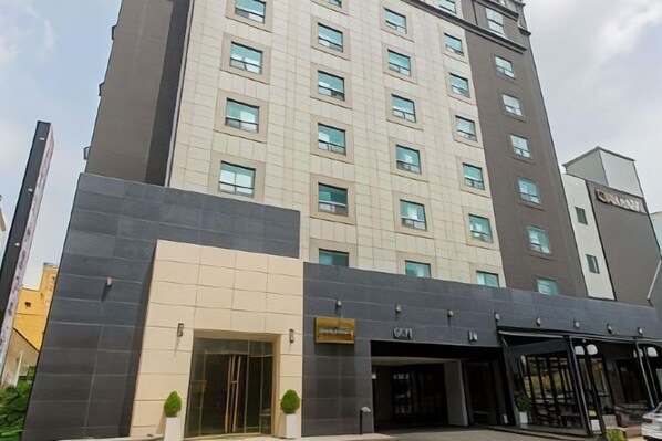 A modern hotel with a prominent entrance, multiple floors, and a visible sign indicating amenities. - Hotel KNOX (Cheonan)