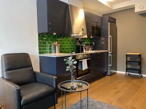 Elite studio | Privékeuken | Een koelkast met diepvriezer, een microgolfoven, een oven, een kookplaat