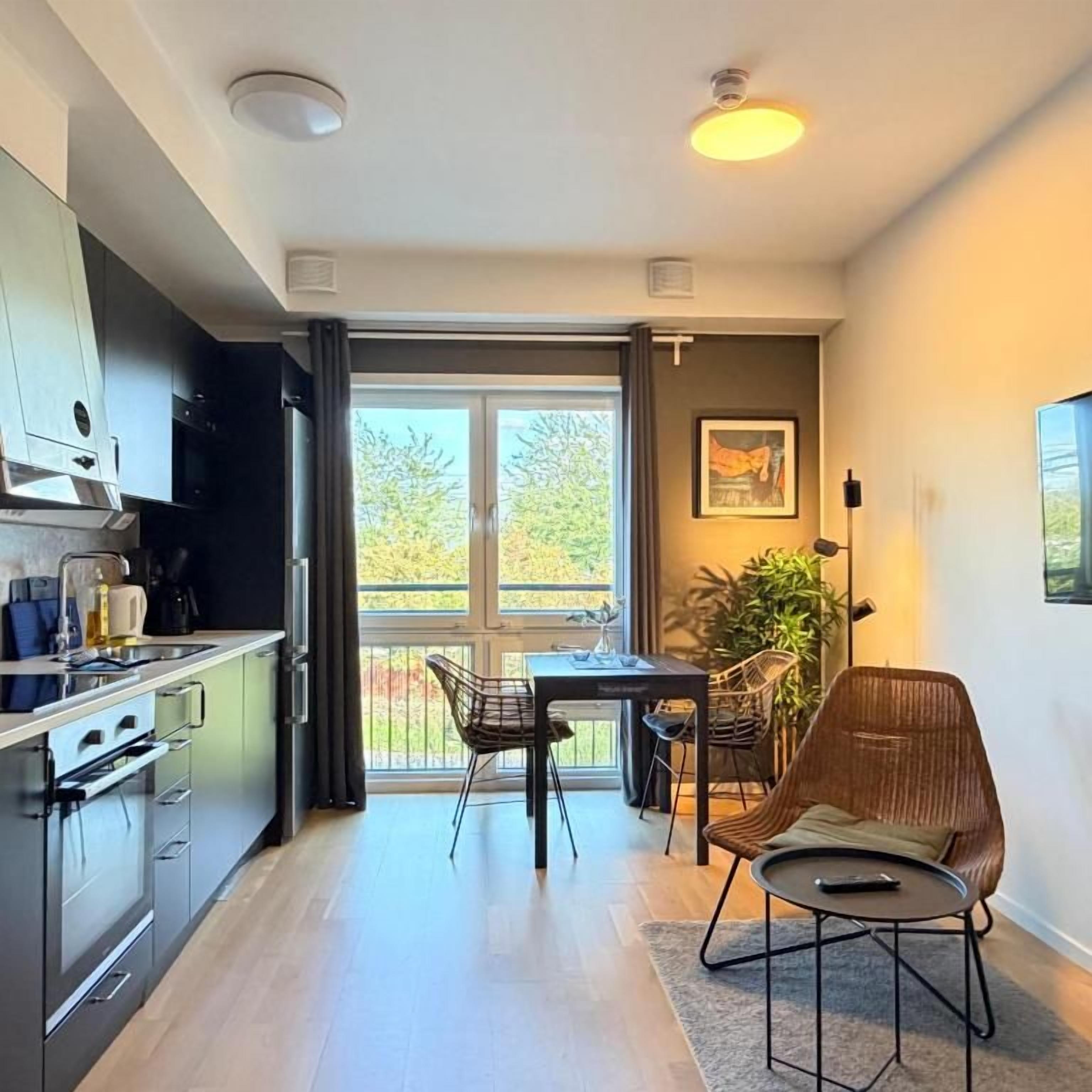 Una cocina moderna con comedor, ventanas amplias y vistas a la vegetación.